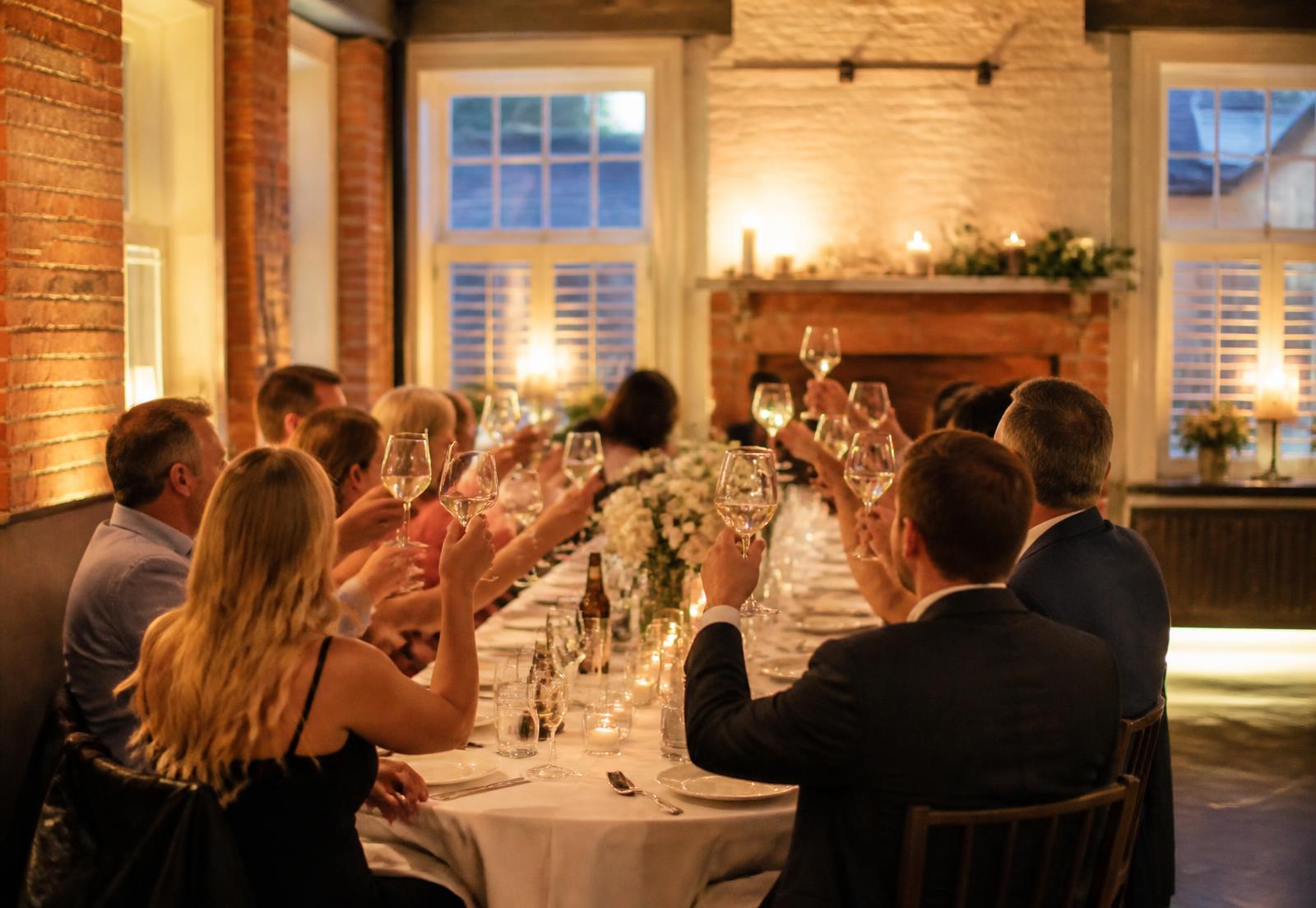 Guests sharing a toast around a long private dinner table