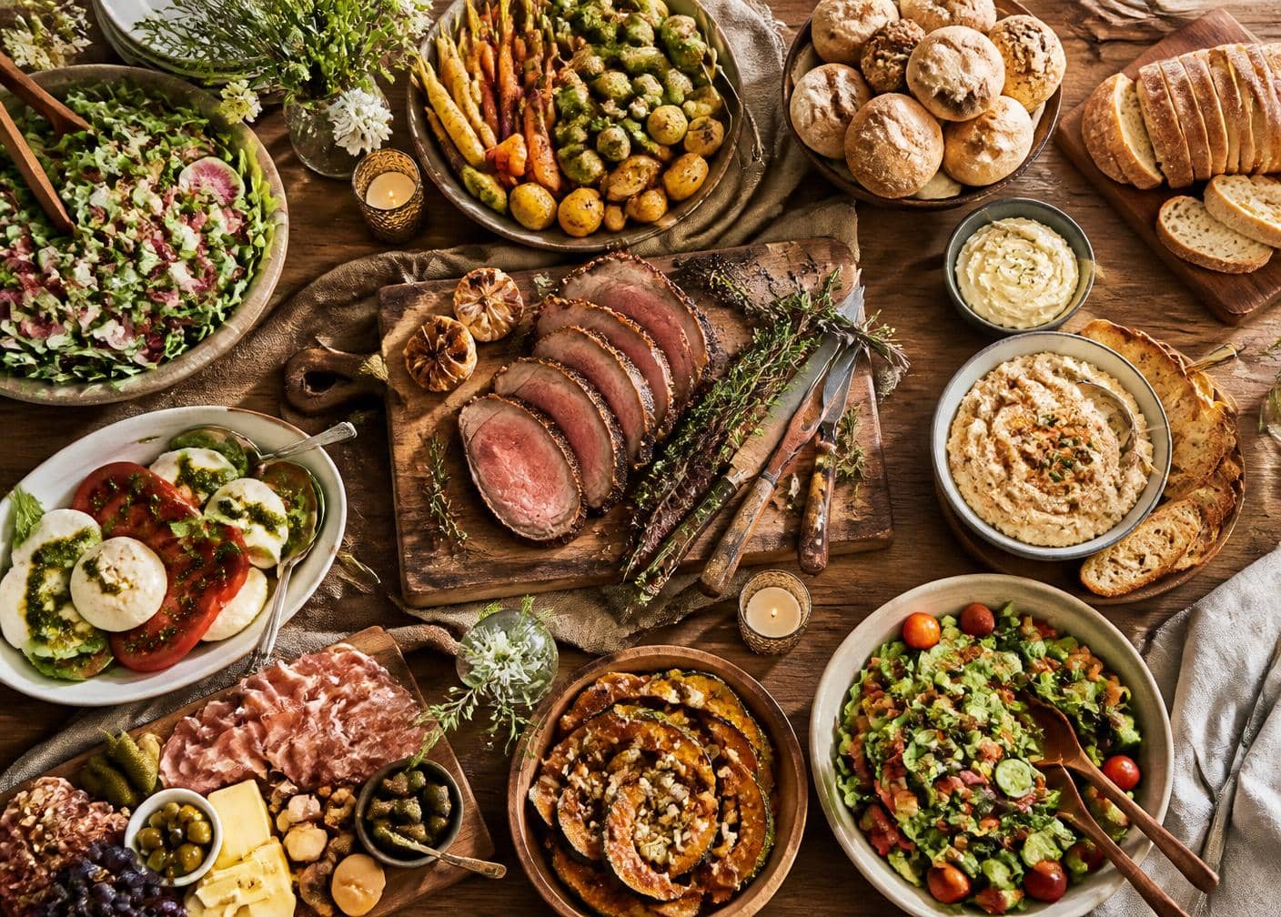 Family-style catering spread on a rustic wooden table
